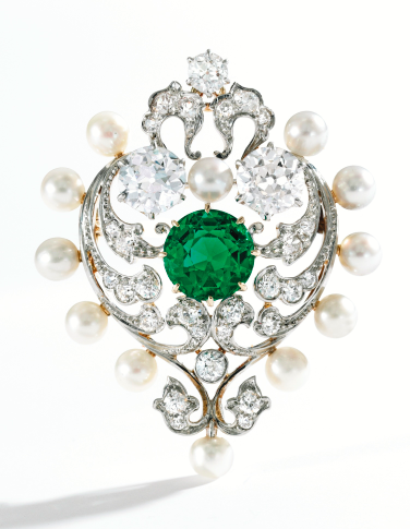 A Gold, Platinum, Emerald, Pearl and Diamond Brooch. Designed as a heart composed of scrollwork motifs, centering a round emerald weighing 2.82 carats, accented by two old European-cut diamonds weighing approximately 2.00 carats, further set with smaller old European and old mine-cut diamonds weighing approximately 1.00 carat, framed by 12 pearls. Signed Marcus & Co., fitted with retractable pendant loop, circa 1900.