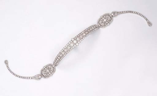 Photo from www.christies.com A Fine Art Deco Metamorphic Diamond Bandeau, by Cartier The central headband of a graduated old-cut diamond shaped-collet line within diamond borders, two oval side panels of foliate design to the diamond line sides, the central part forming a brooch/bracelet, also forming a choker necklace with the diamond line sides, the side panels forming a pendant necklace, one oval panel forming a brooch, circa 1925, with French assay marks for platinum, in original pink leather fitted case (damaged), with all fittings, adaption tool and contemporary drawing (damaged) of bandeau One oval panel signed Cartier, Paris, London, New York (5)