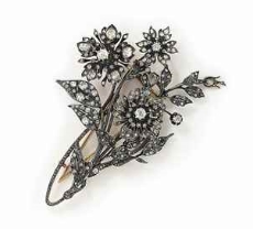 A late 19th century diamond brooch and pin with two diamond cluster flower-heads set en tremblant, mounted in silver and gold, circa 1890. Up for auction at Christie’s this April, it features old circular-, rose-, and single-cut diamonds.