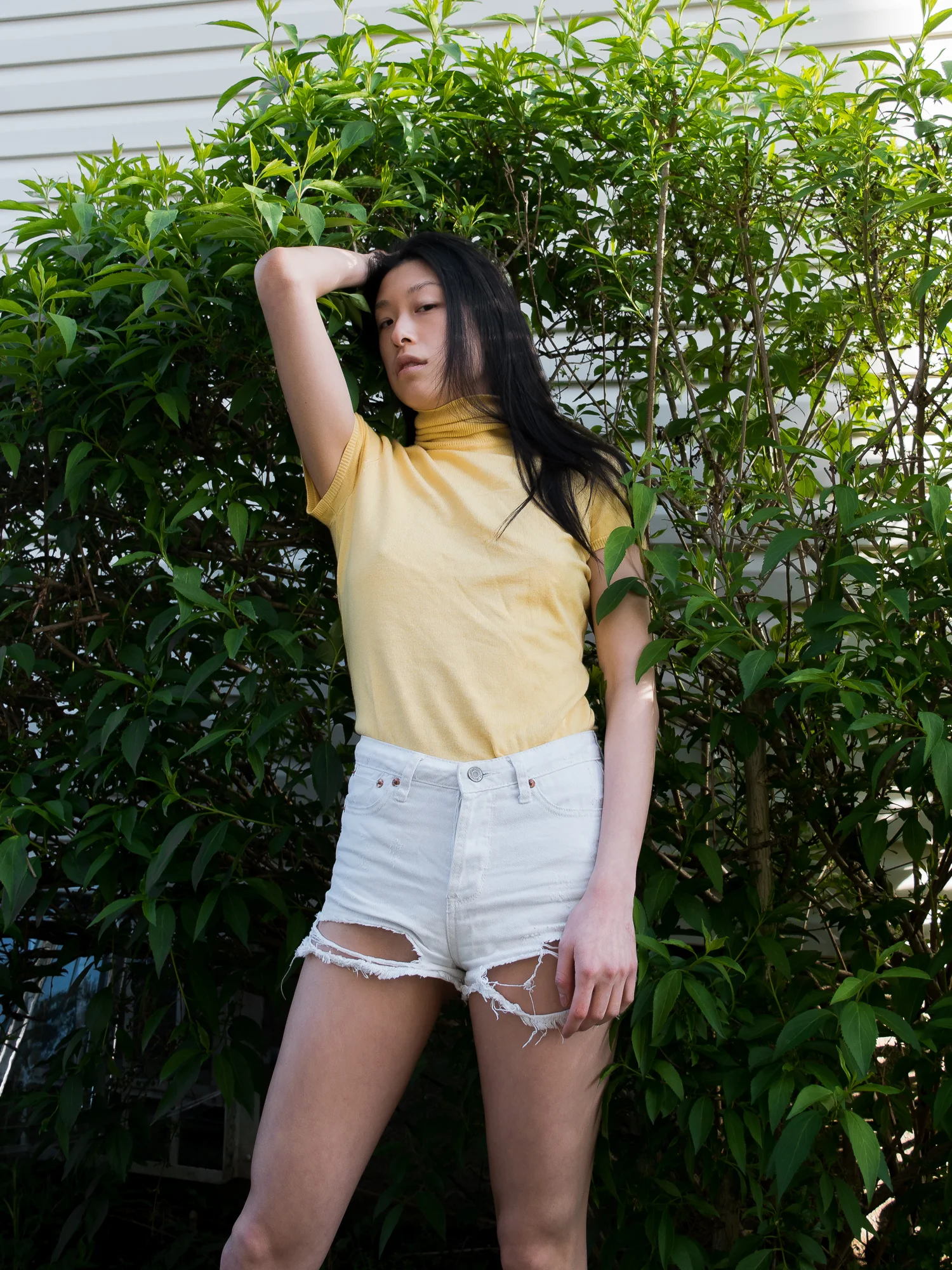 Cute summer outfit close-up, yellow top, white shorts