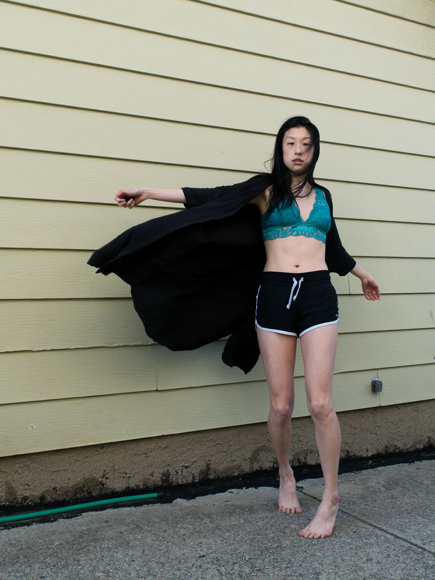 East asian female style blogger in blue bralette, white athletic shorts, and black shirt-dress