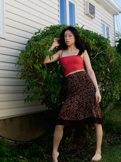 Female east asian style blogger wearing orange crop top and brown polka dot skirt
