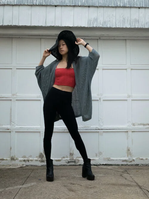 Seagreen knit cardigan, orange textured crop top, black leggings, black platform boots, black floppy hat
