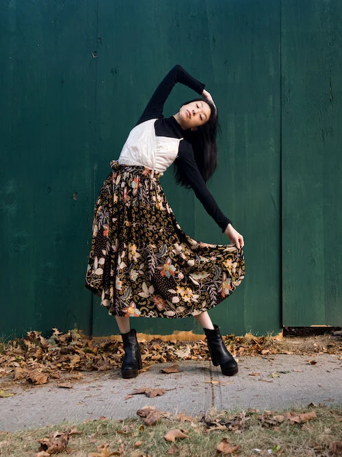 Black turtleneck, silver gold dress, floral skirt, black shoes