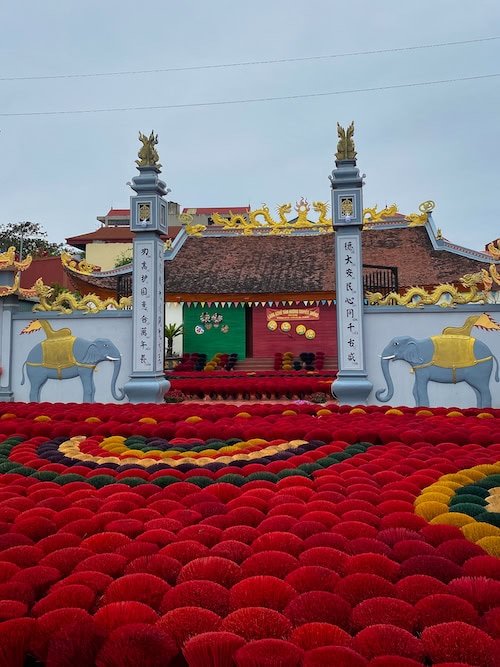 outdoor red and yellow display of incense bundles at incense village hanoi