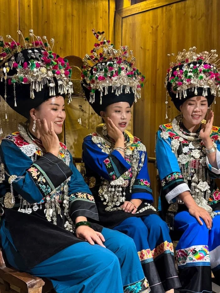 Three Miao women in traditional dress.