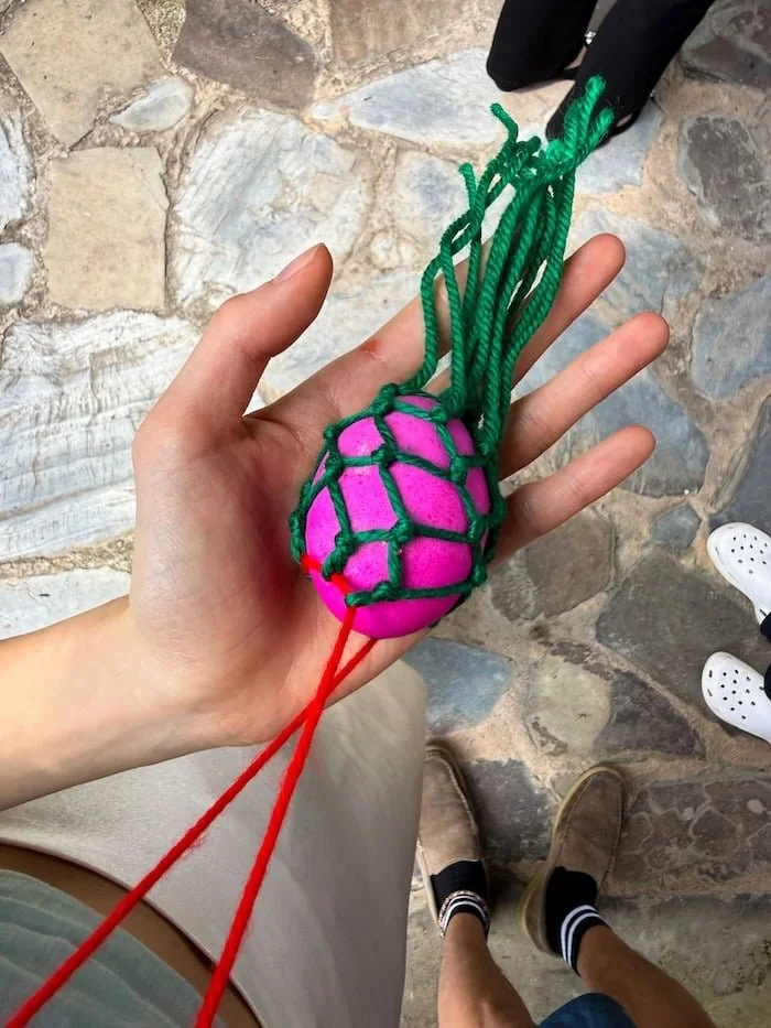 Traveler holding a pink dyed egg—a lucky talisman from the Miao. 