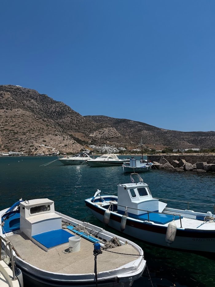  Small fishing boats moored at a Greek island harbor. The best eSIM for Greece keeps you connected around the islands. 