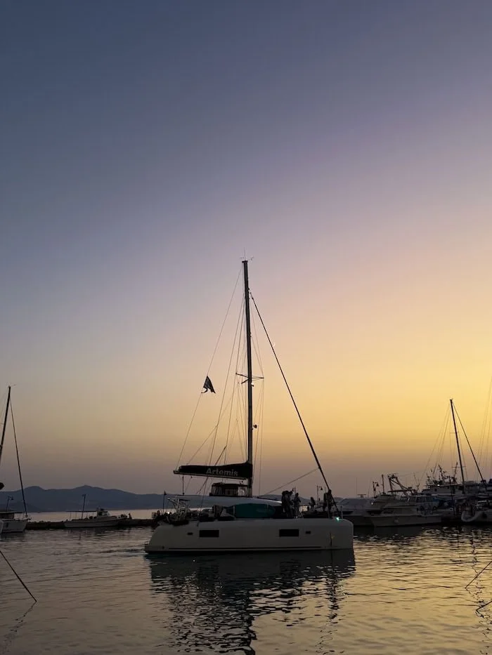  Sailboat docked in a Greek harbor at sunset. The best eSIM for Greece keeps you connected throughout your island adventure. 