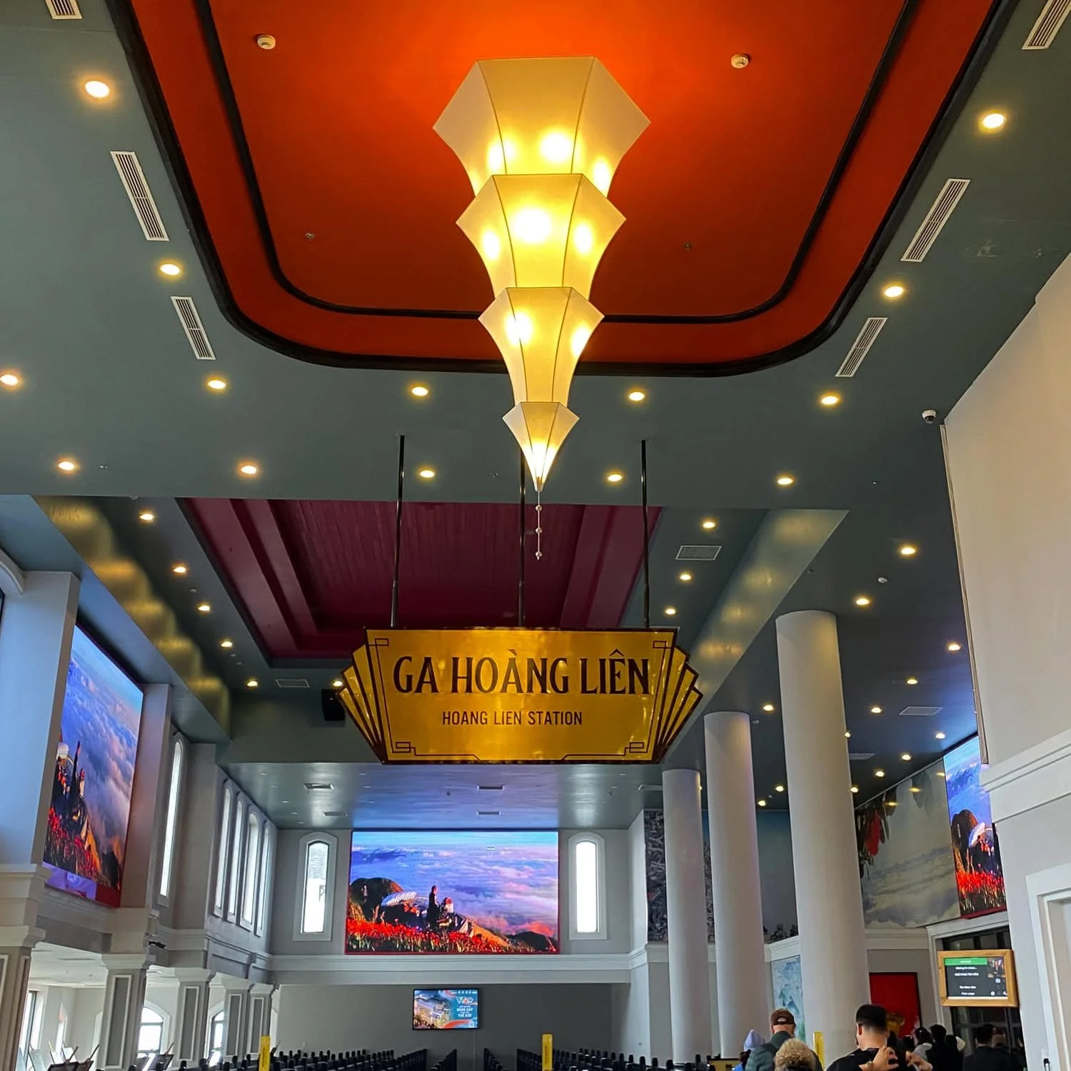 The interior of Ga Hoàng Liên station, a terminal for the Fansipan cable car, with a large yellow sign and decorative lighting.