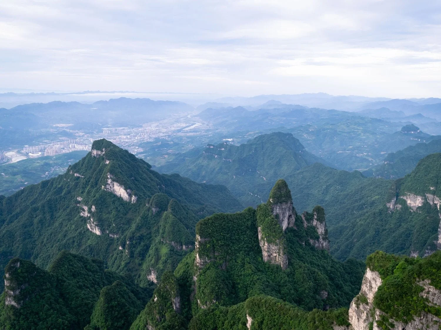 A panoramic view of forested mountain peaks stretches across the landscape. Choosing the right group tour China itinerary helps ensure you see the destinations and experiences that matter most to you.