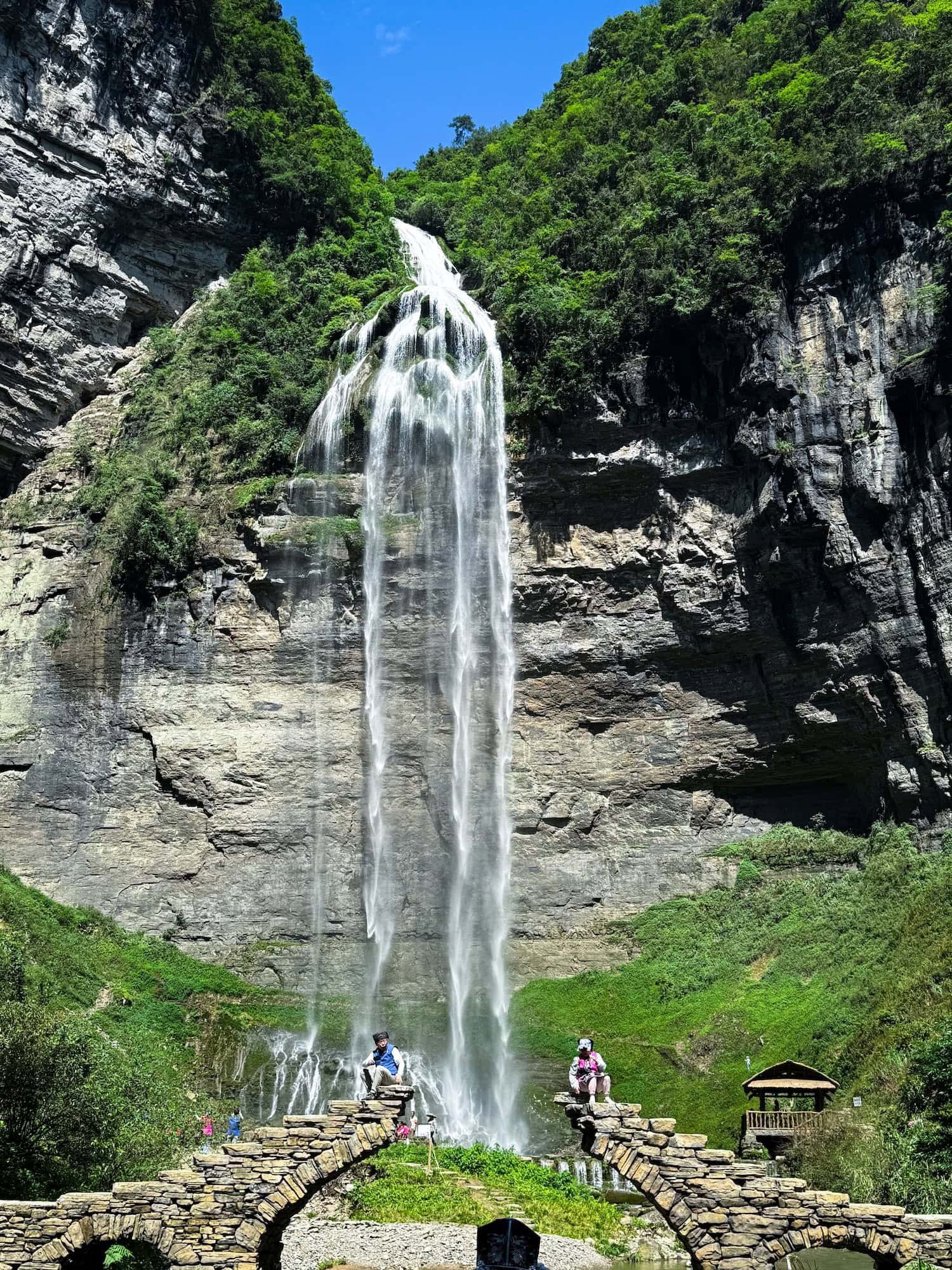 Liusha Waterfall cascading down a cliff in Guizhou, China. This 2 week China itinerary features incredible natural attractions.