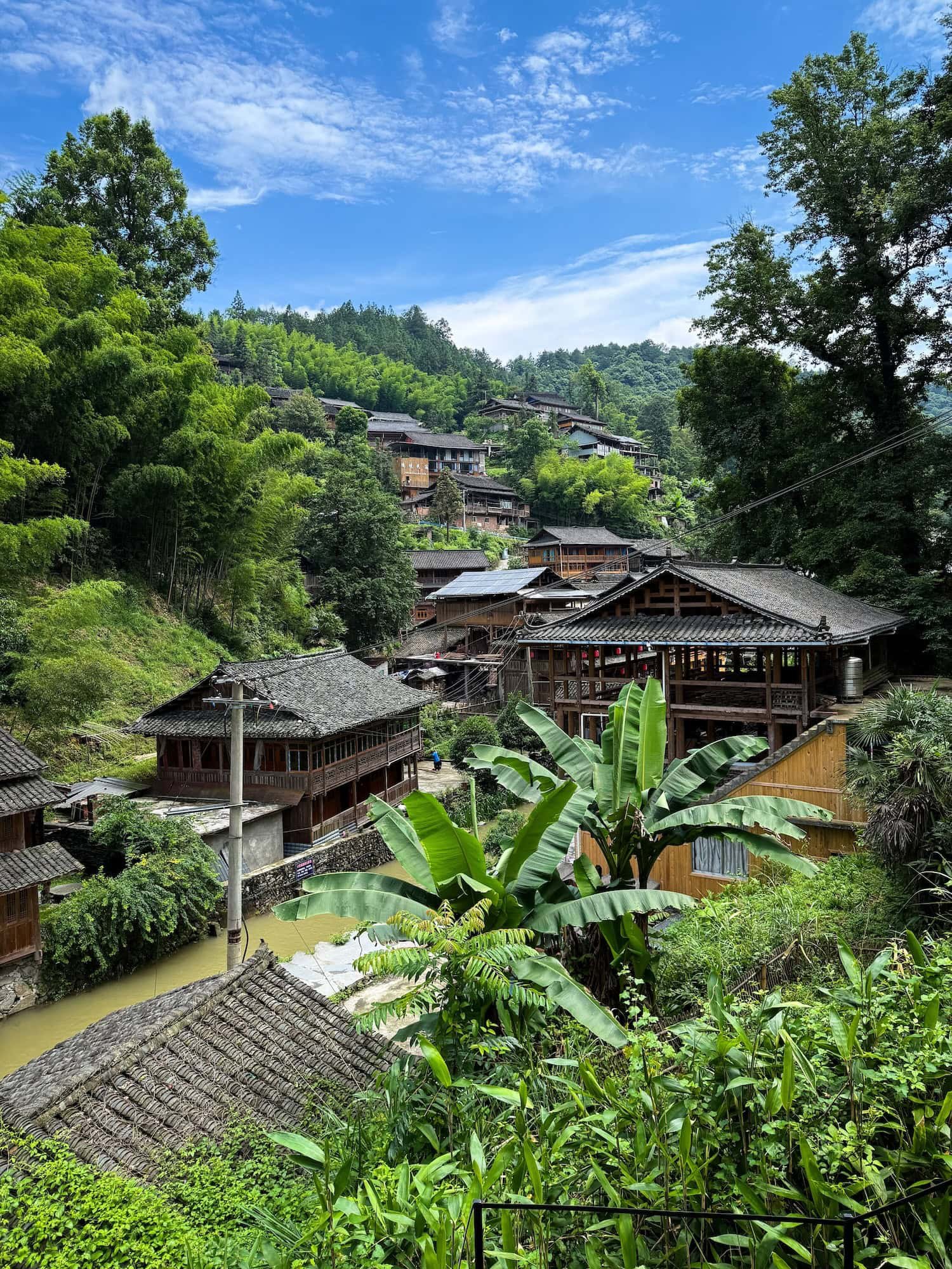 View of a lush mountain village in Guizhou, China. This 2 week China itinerary explores China's beautiful rural landscapes.