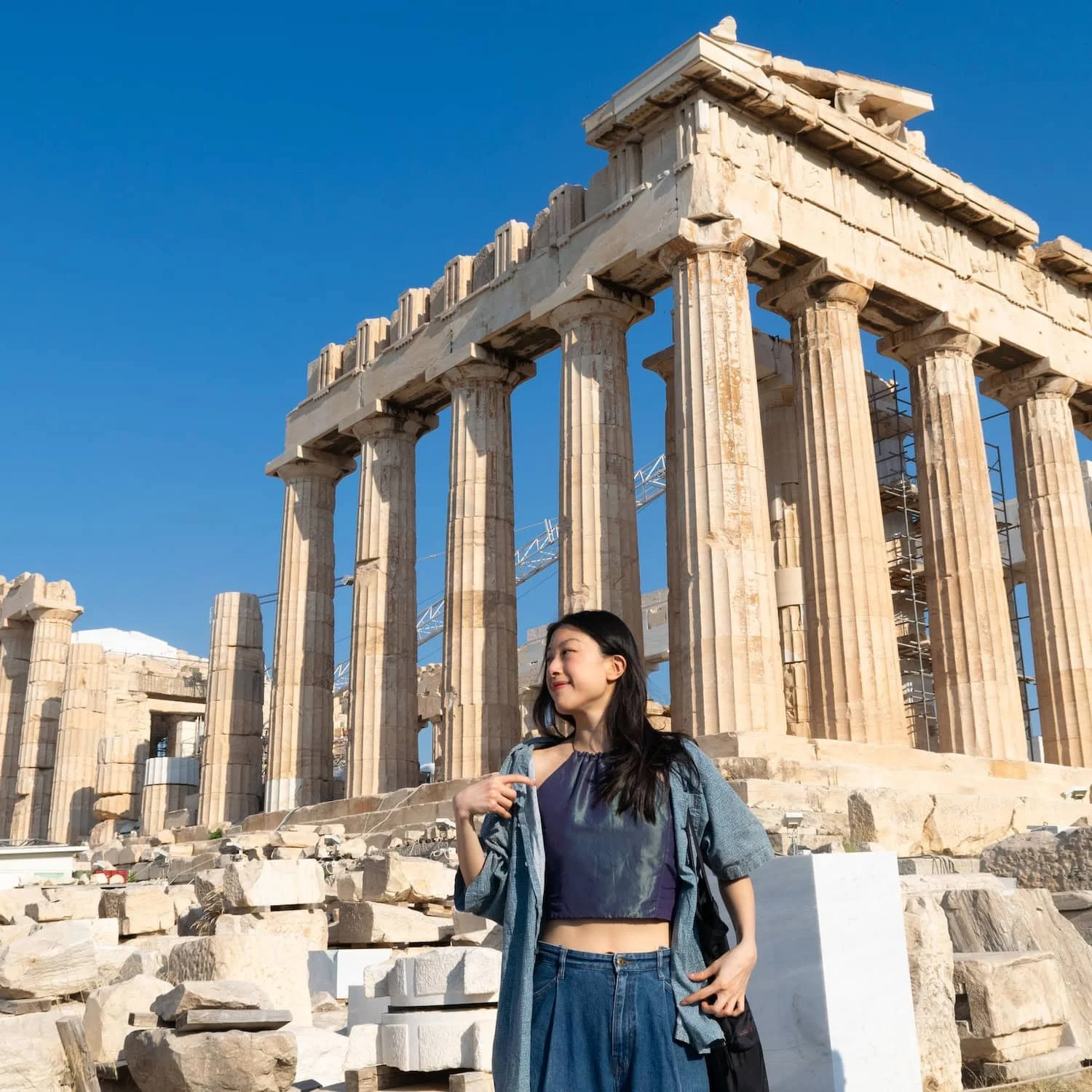 Woman standing in front of the Parthenon in Athens, Greece. The best eSIM for Greece makes staying connected while sightseeing easy.