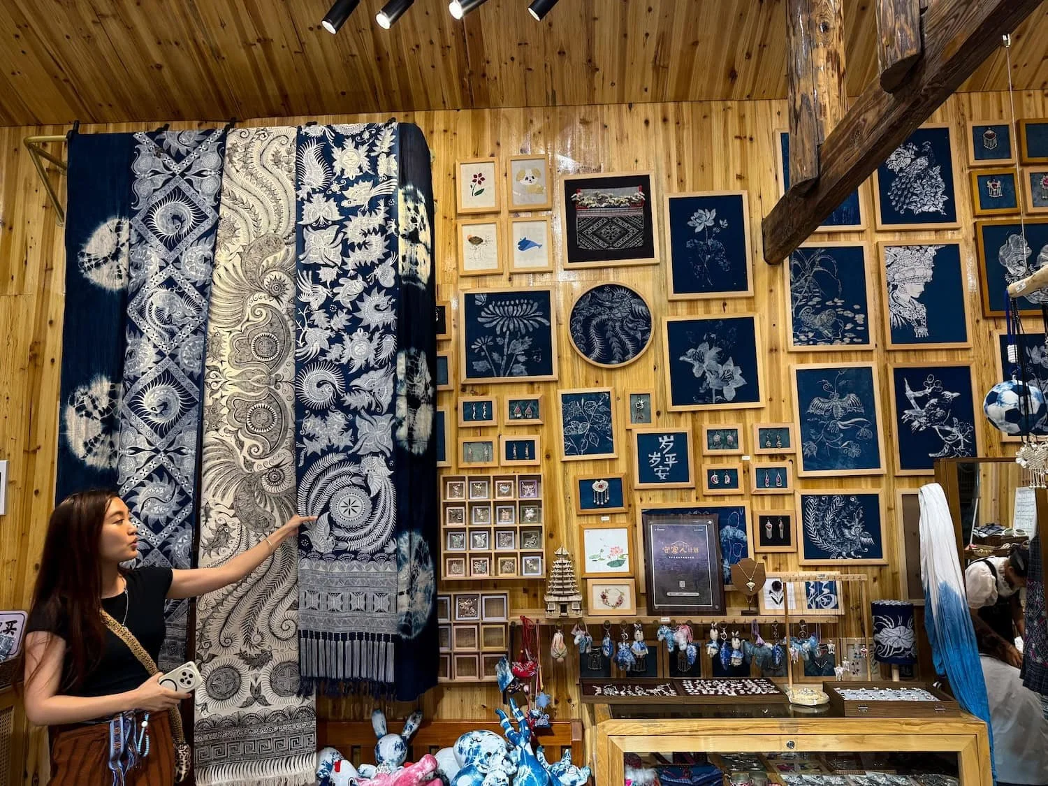 Zihan, an Eastogo guide, explaining traditional indigo-dyeing techniques inside a local artisan shop. Eastogo supports meaningful cultural experiences by introducing travelers to local artisans across China.