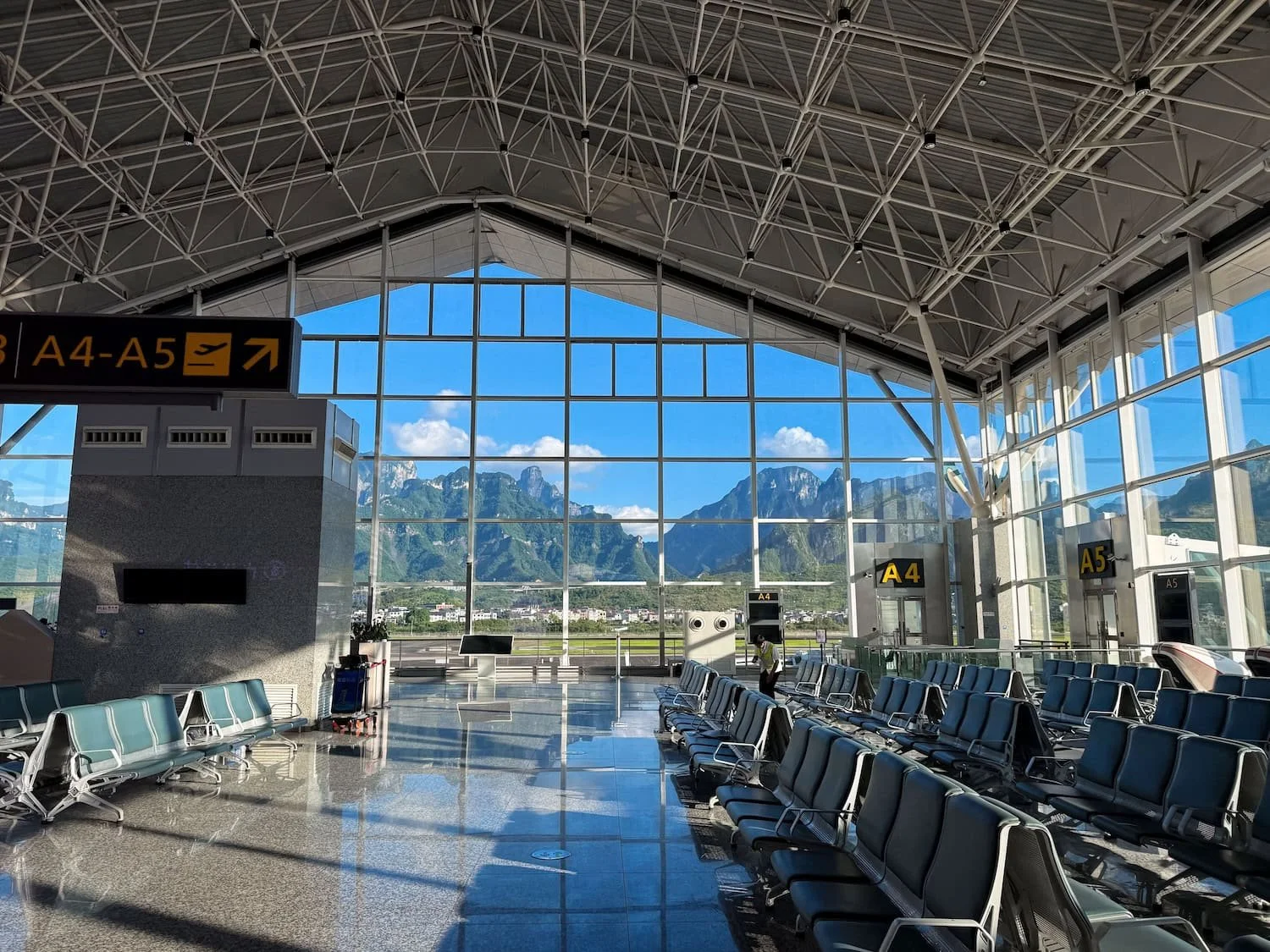 Airport departure gate with panoramic views of karst mountains through large windows. Smooth travel logistics like these are part of the overall Eastogo travel experience in China.