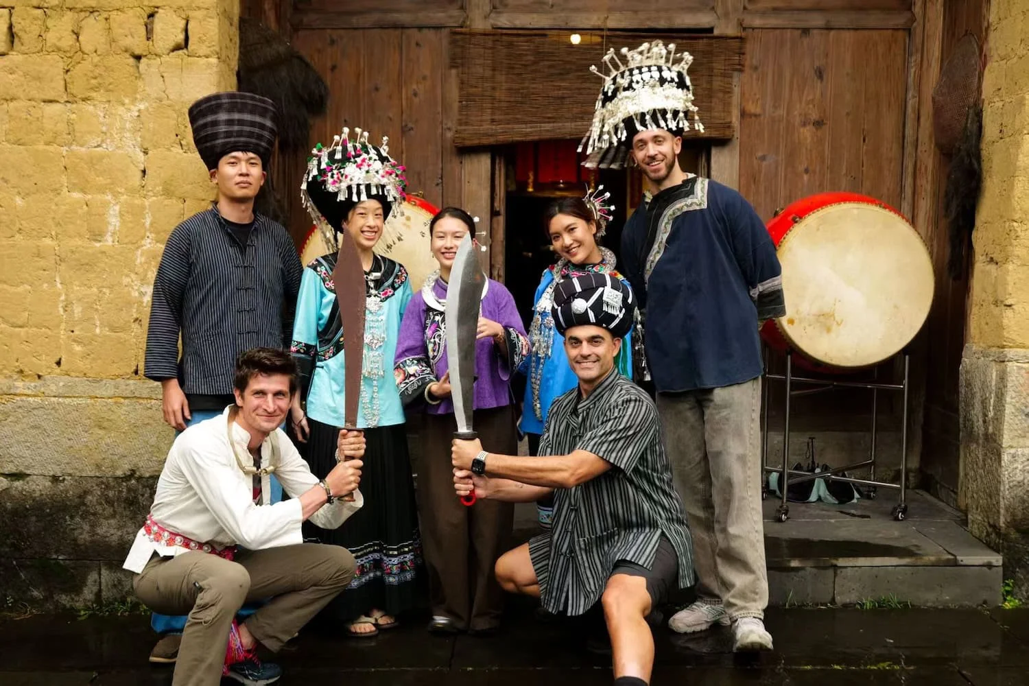 Small group of travelers posing with local villagers in traditional Miao clothing. Eastogo's small group travel in China creates more personal cultural experiences and meaningful interactions.