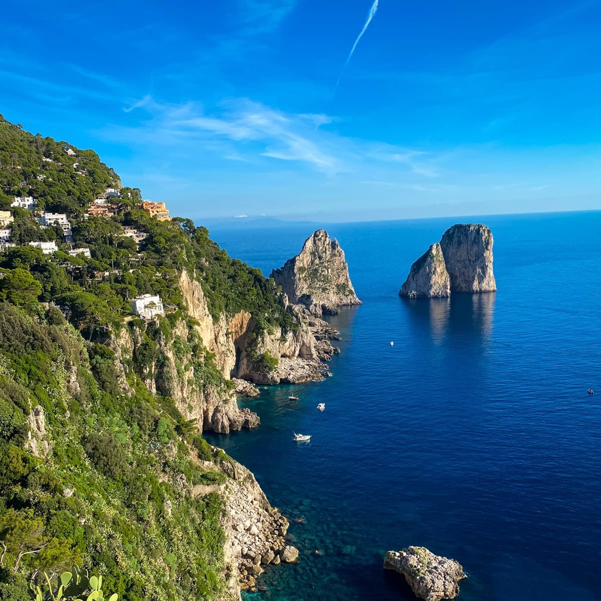 Picture-perfect coastal shot of Capri’s famous sea stacks (Faraglioni rocks) with dramatic cliffs and crystal-clear waters. Great visual for the natural beauty near accommodations in Capri Town.