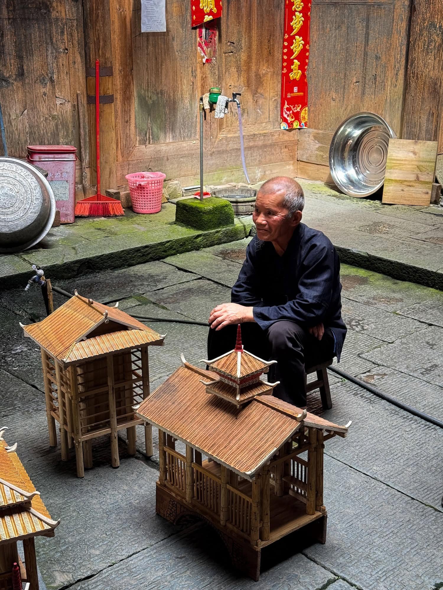 Elder crafting wooden models in a traditional Dong village. This 2 week China itinerary highlights authentic local culture.