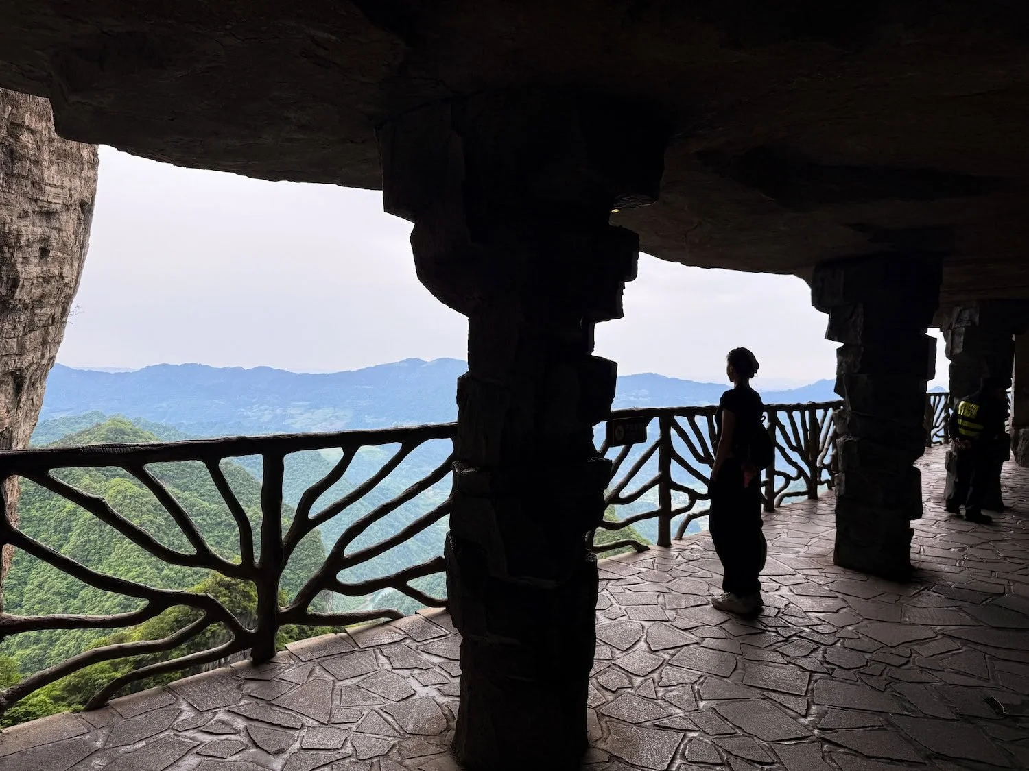 Traveler admiring mountain views from a cliffside observation deck at a Tianmen Mountain in Zhangjiajie. Eastogo allows time to appreciate China's famous landmarks without feeling rushed.