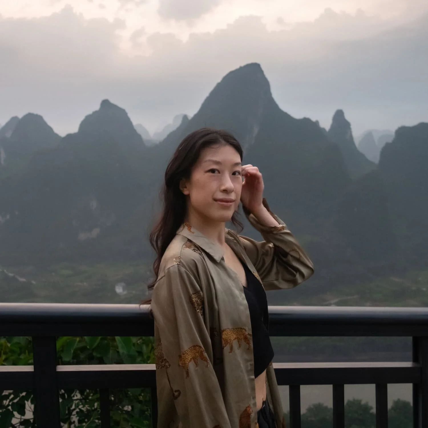 A traveler stands on a viewpoint overlooking dramatic karst mountains in southern China. This landscape highlights the destinations many first-time visitors can experience on a group tour China itinerary.