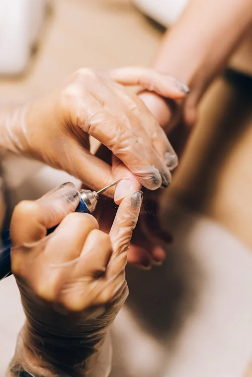 A manicure expert preparing nails before applying base coat