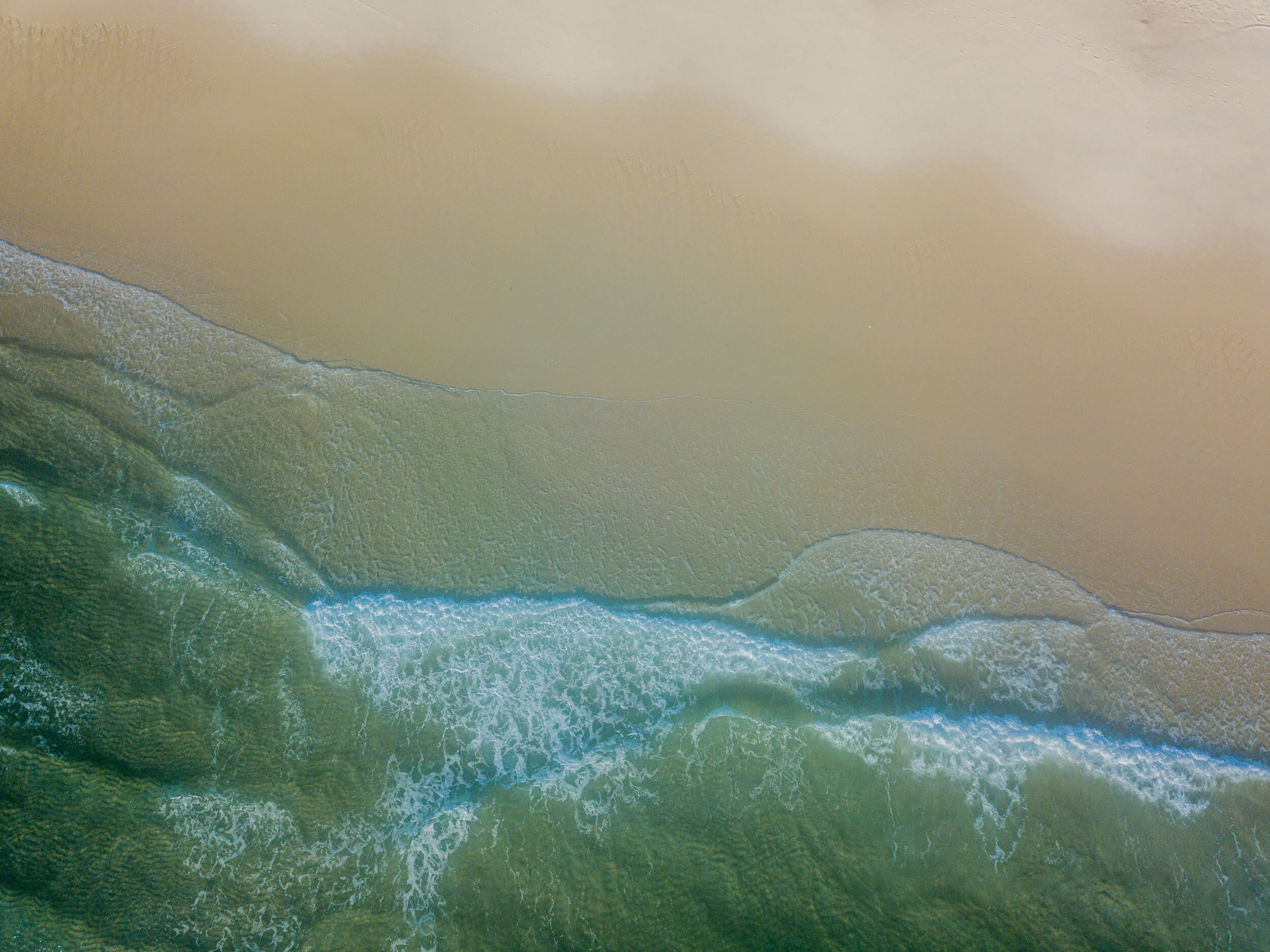 drone-picture-of-waves-hitting-the-beach-HMLYG5R.jpg