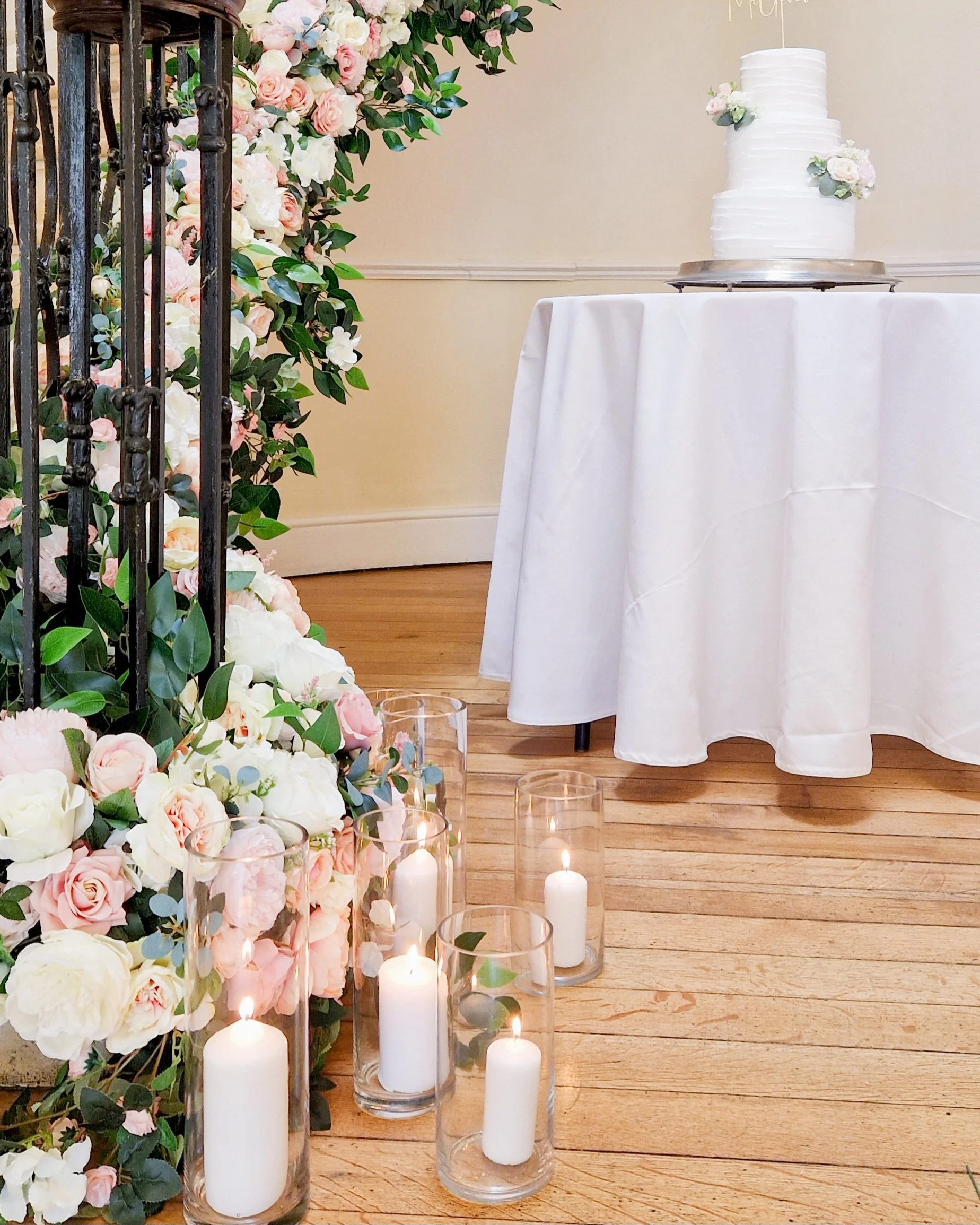 The staircase at Eastington Park styled with a blush pink and ivory garland and cylinder vases