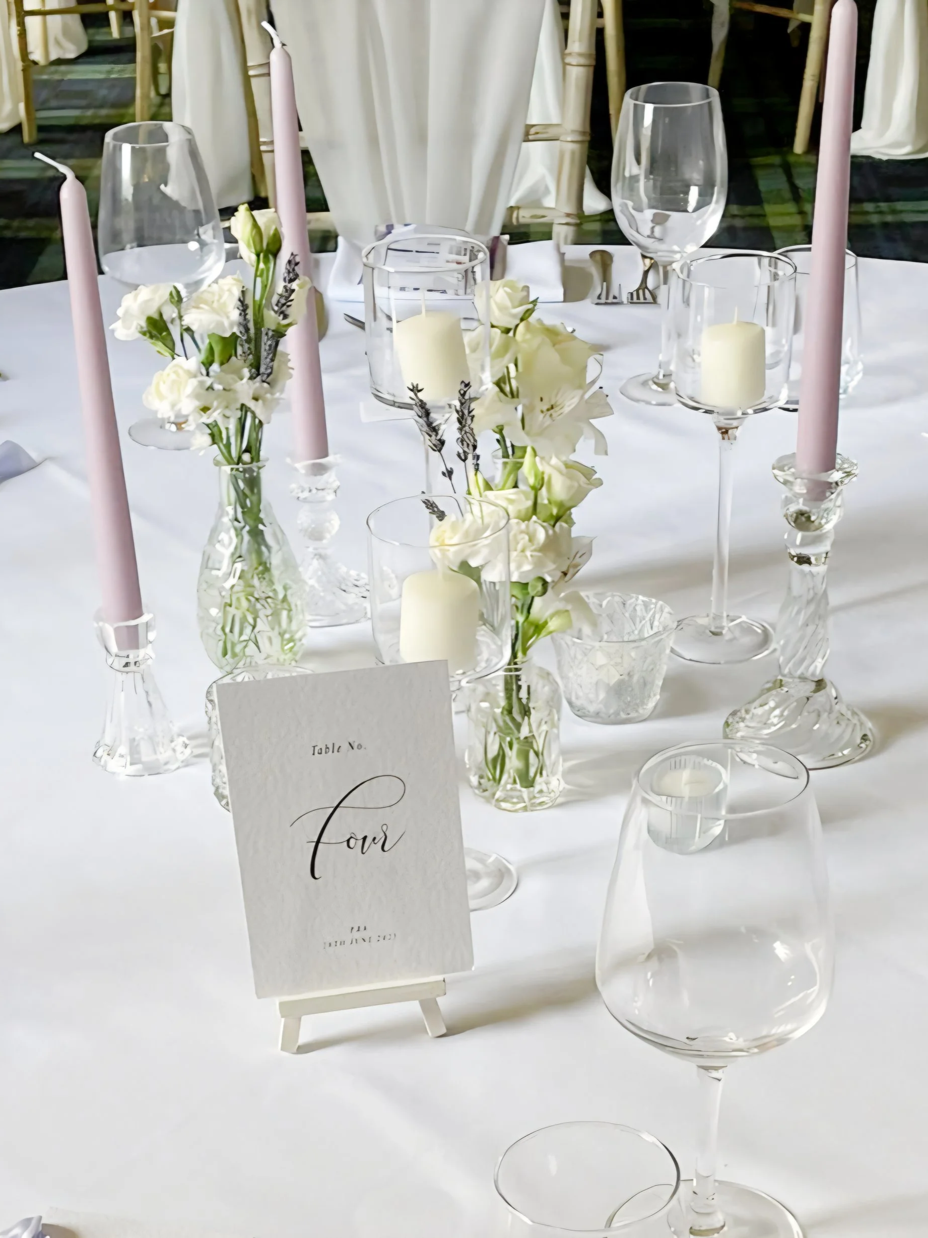 Bud vases with ivory stems and glass candlestick centrepiece in the Cotswolds