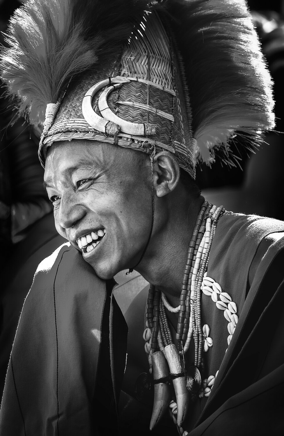 young naga enjoying hornbill festival and laughing in black and white portrait