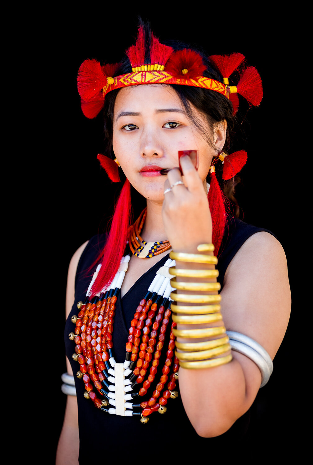 Beautiful young woman with tribal attire and pipe during hornbill festival in nagaland