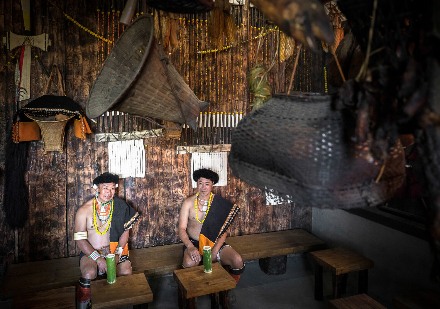 naga men in traditional attire enjoying zutho in tribal home during hornbill festival in nagaland