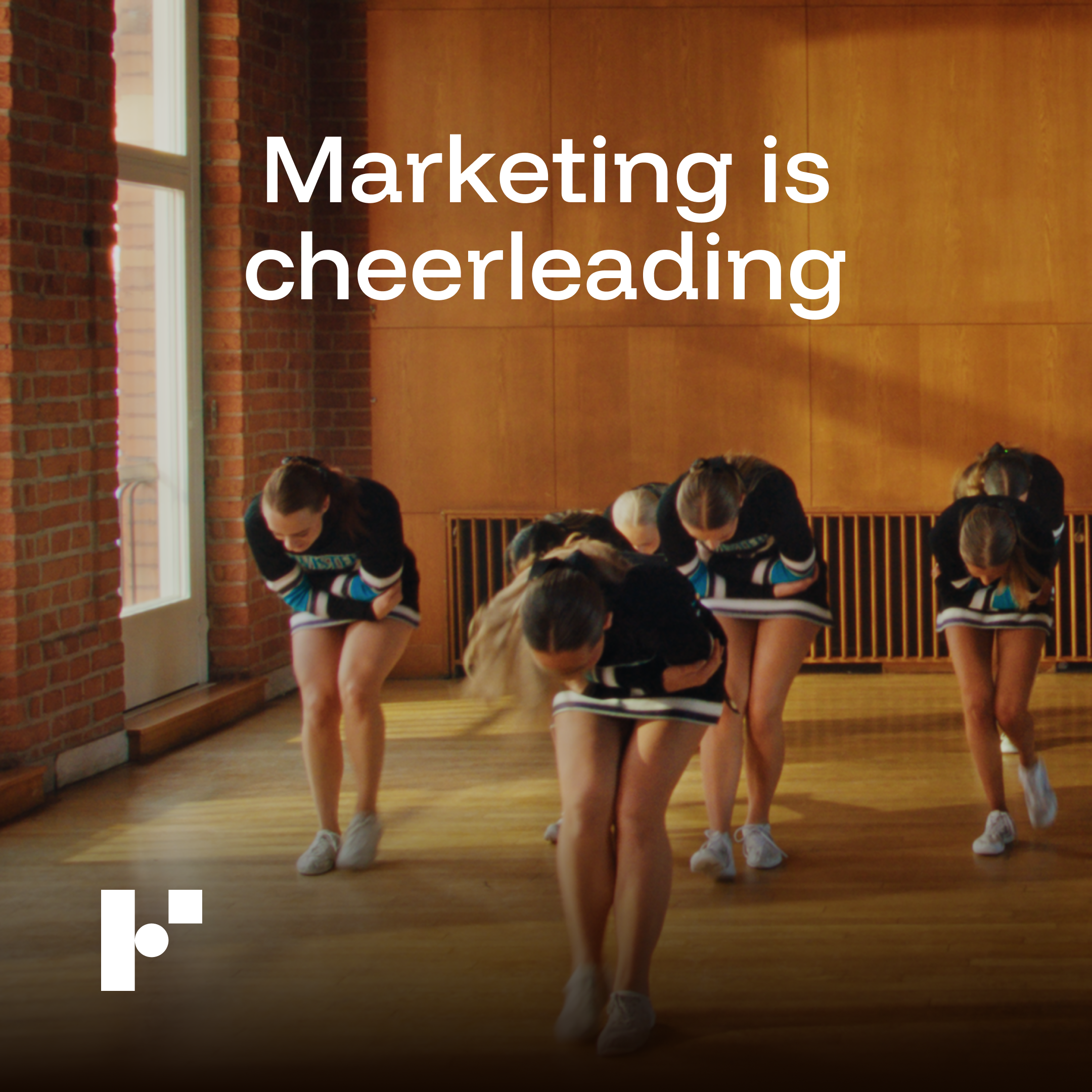 Group of cheerleaders bowing in a gym with wooden floors and brick walls, text overlay reads 'Marketing is cheerleading'.