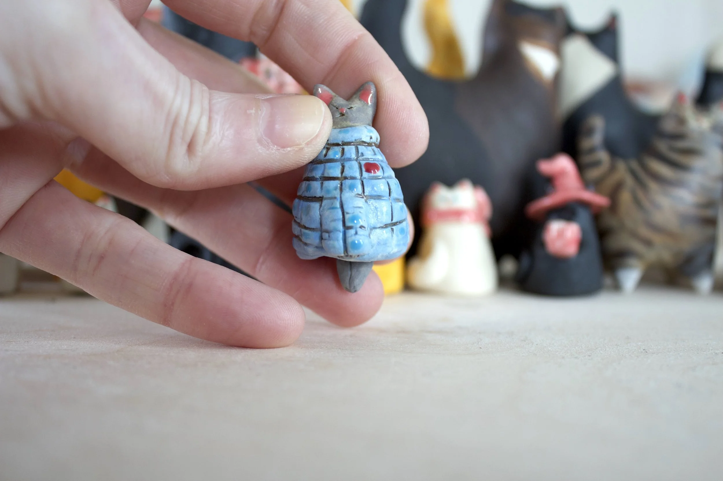 Sphynx ceramic cat chime shown in hand for scale.jpeg