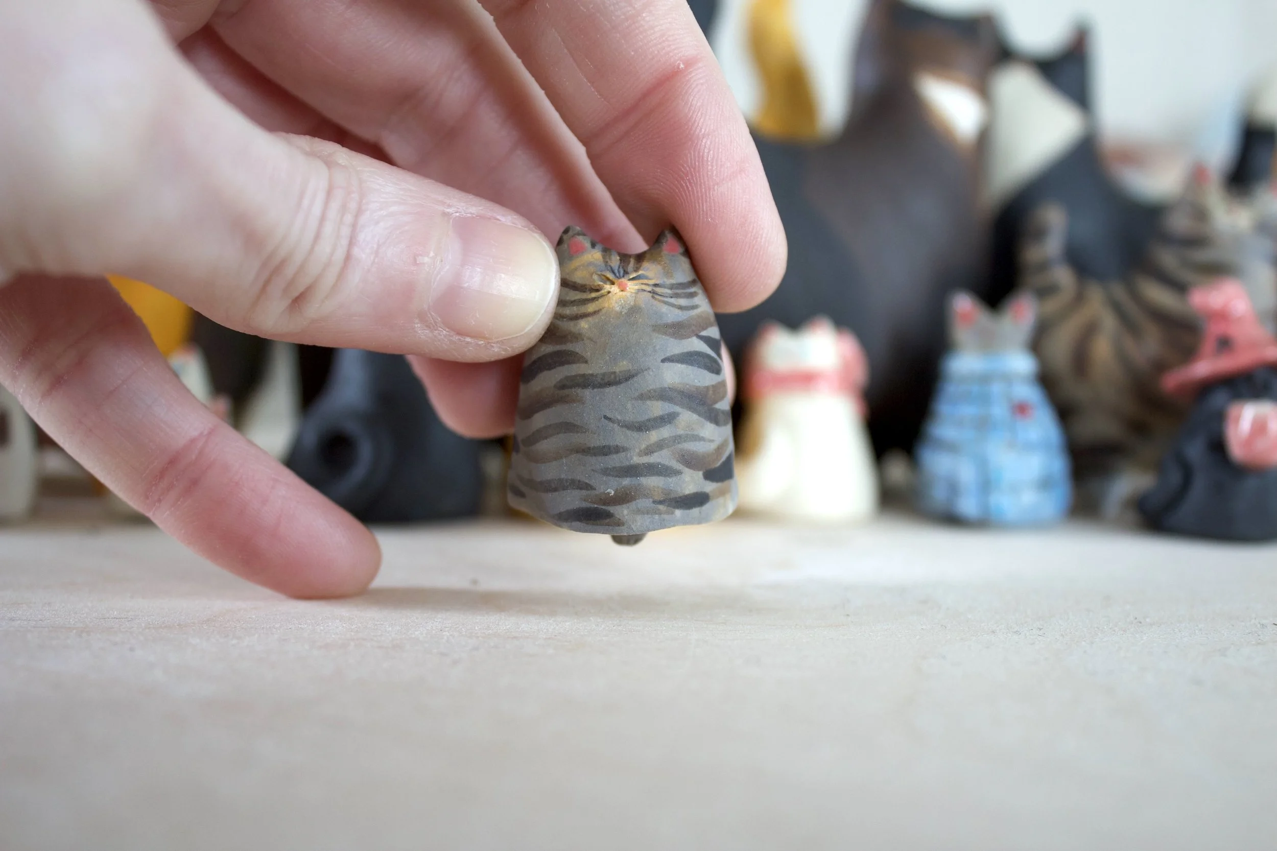 Standard Issue Tabby ceramic cat chime shown in hand for scale.jpeg