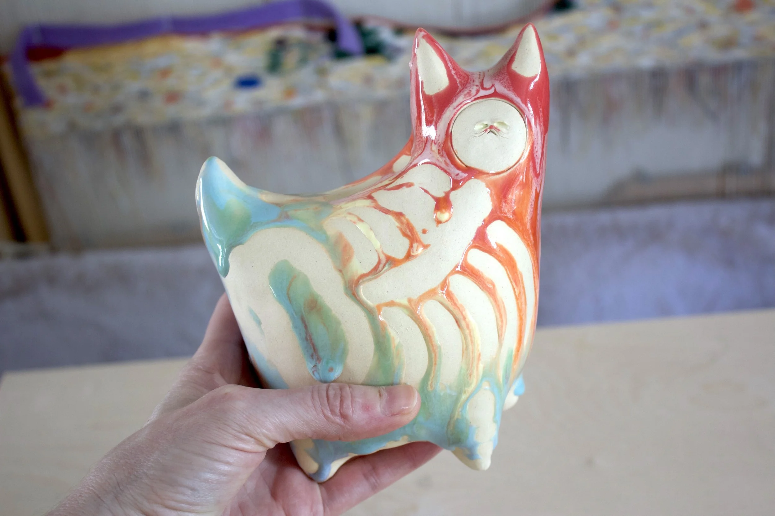 Handmade XL ceramic Pastel Goo Skeleton White Cat shown in hand to demonstrate size and scale.jpeg