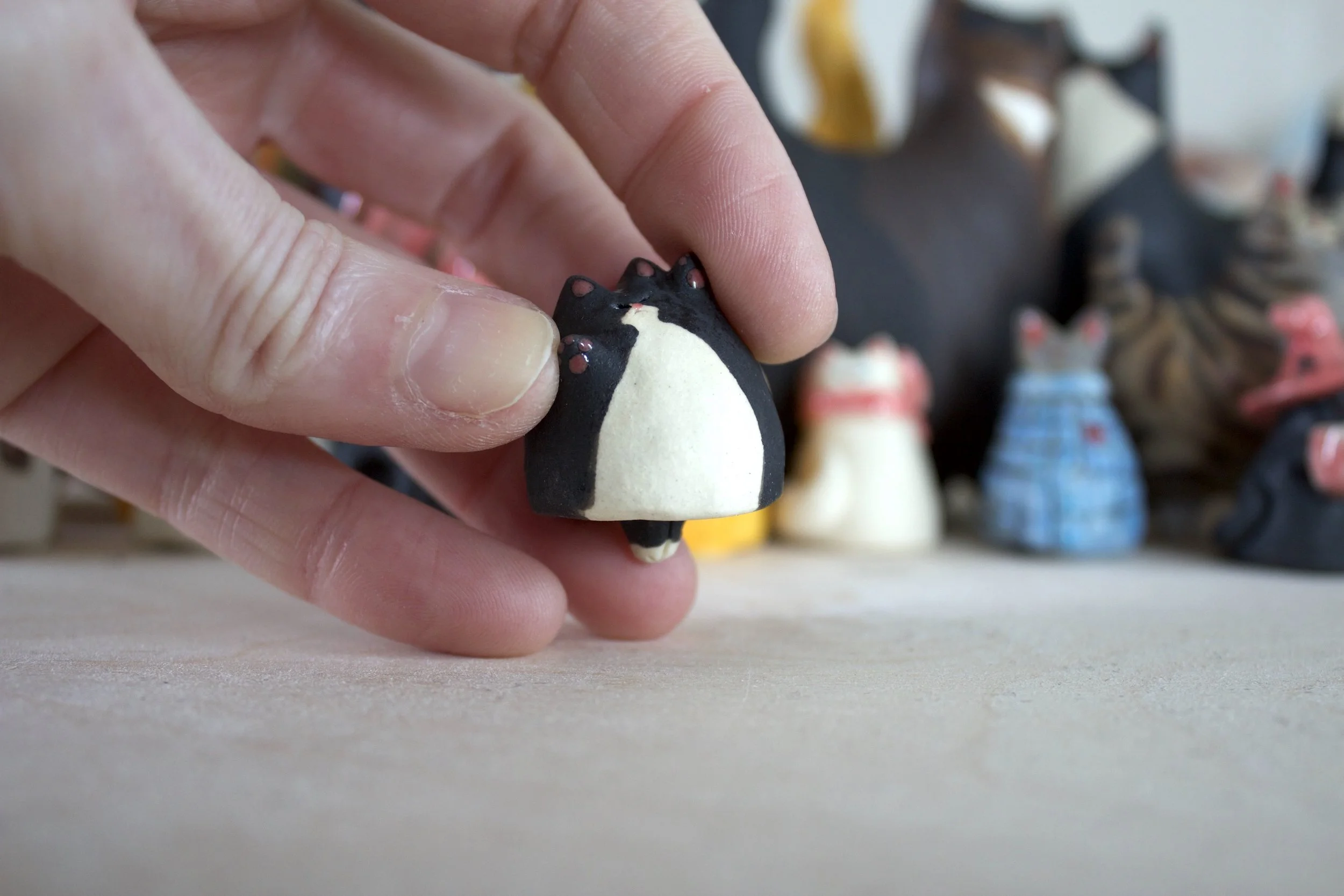 Tuxedo ceramic cat chime shown in hand for scale.jpeg