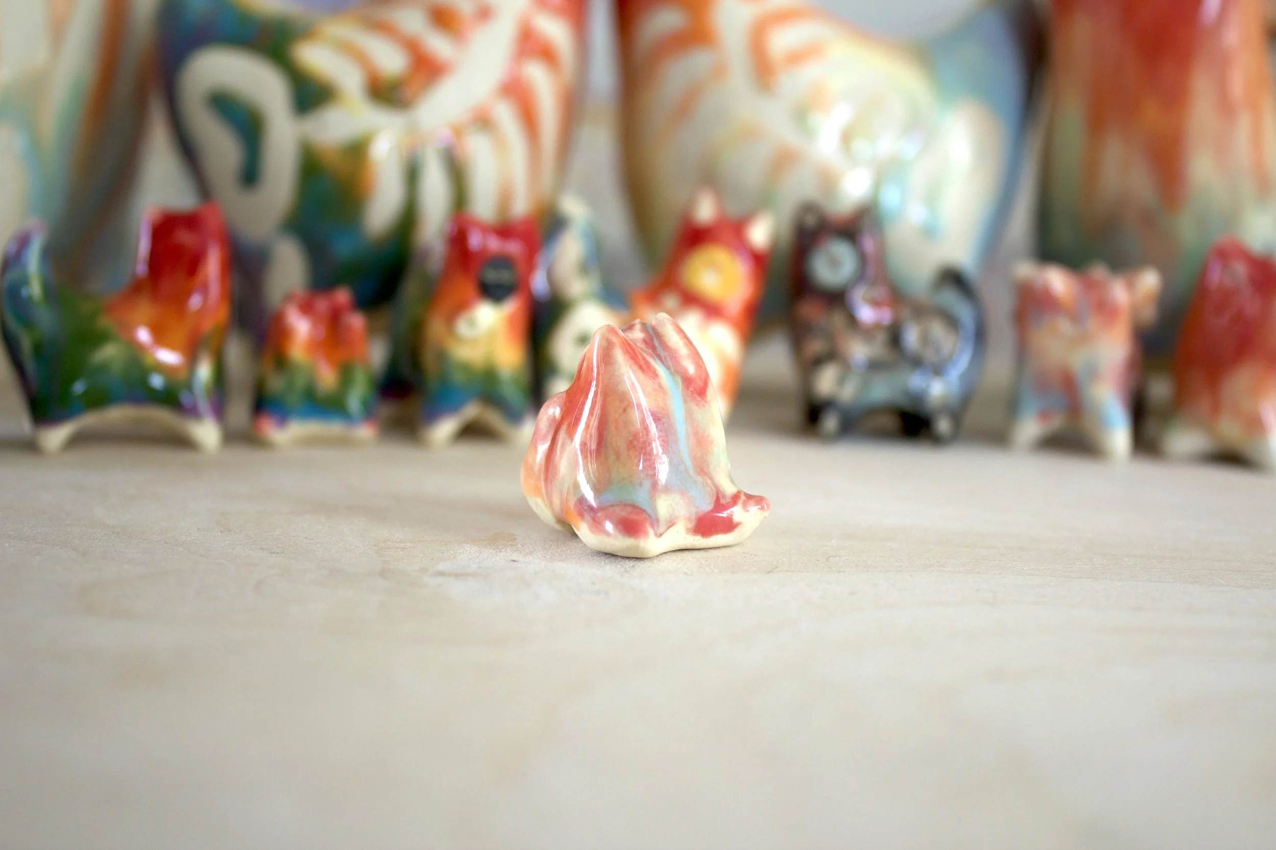 Three-quarter view of Pastel Rainbow Cat No. 1, a handmade ceramic cat sculpture.jpeg