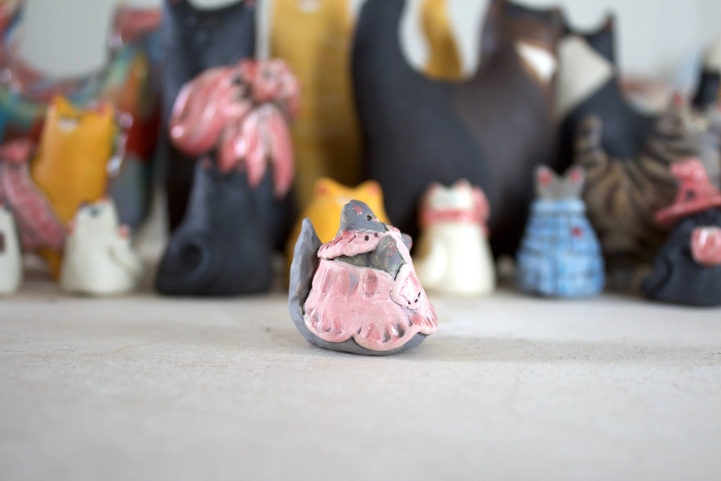 Cozy gray ceramic cat handmade sculpture with pink apron detail.jpeg
