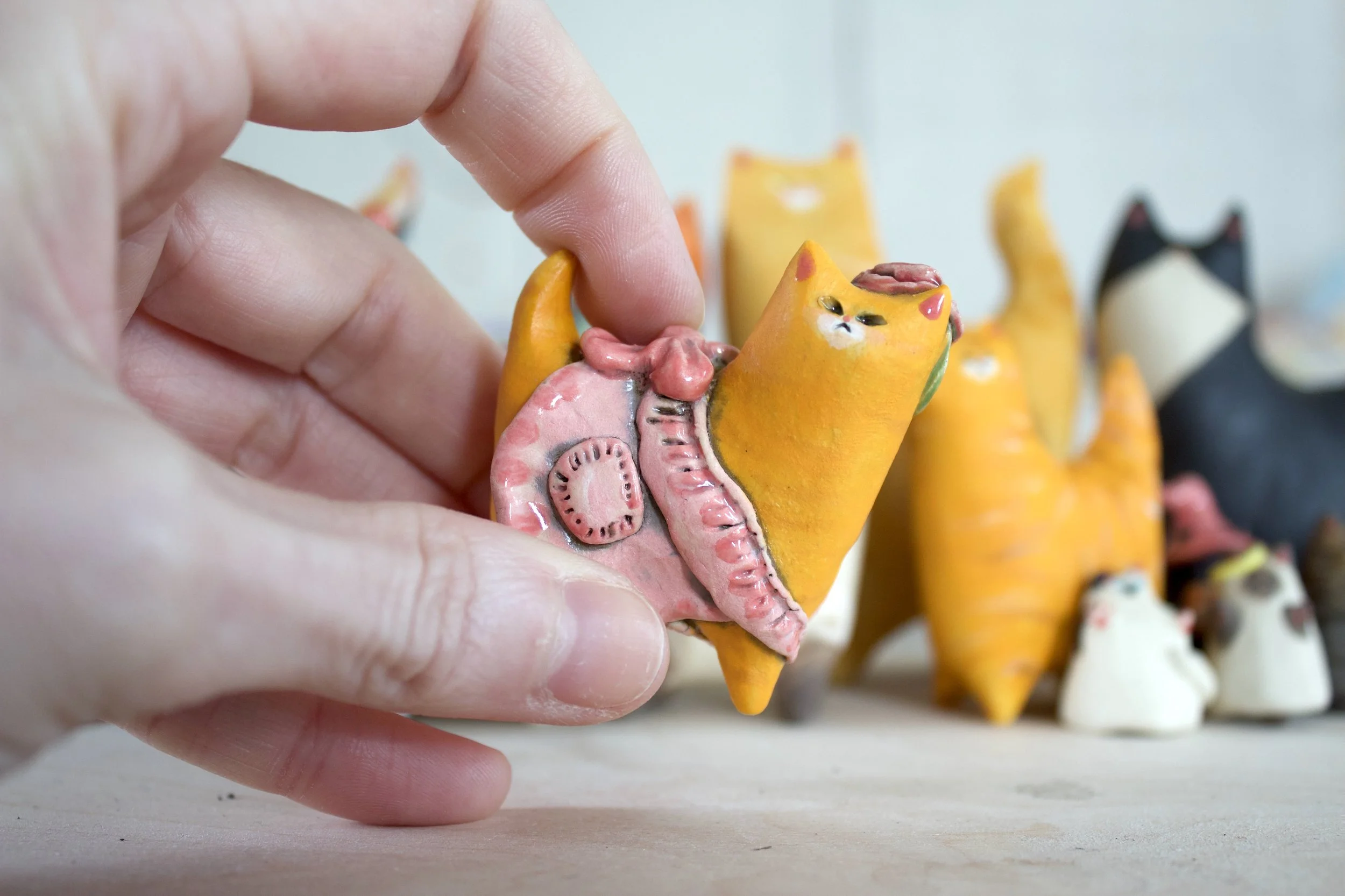 Ginger Tabby ceramic cat sculpture shown in hand for scale.jpeg
