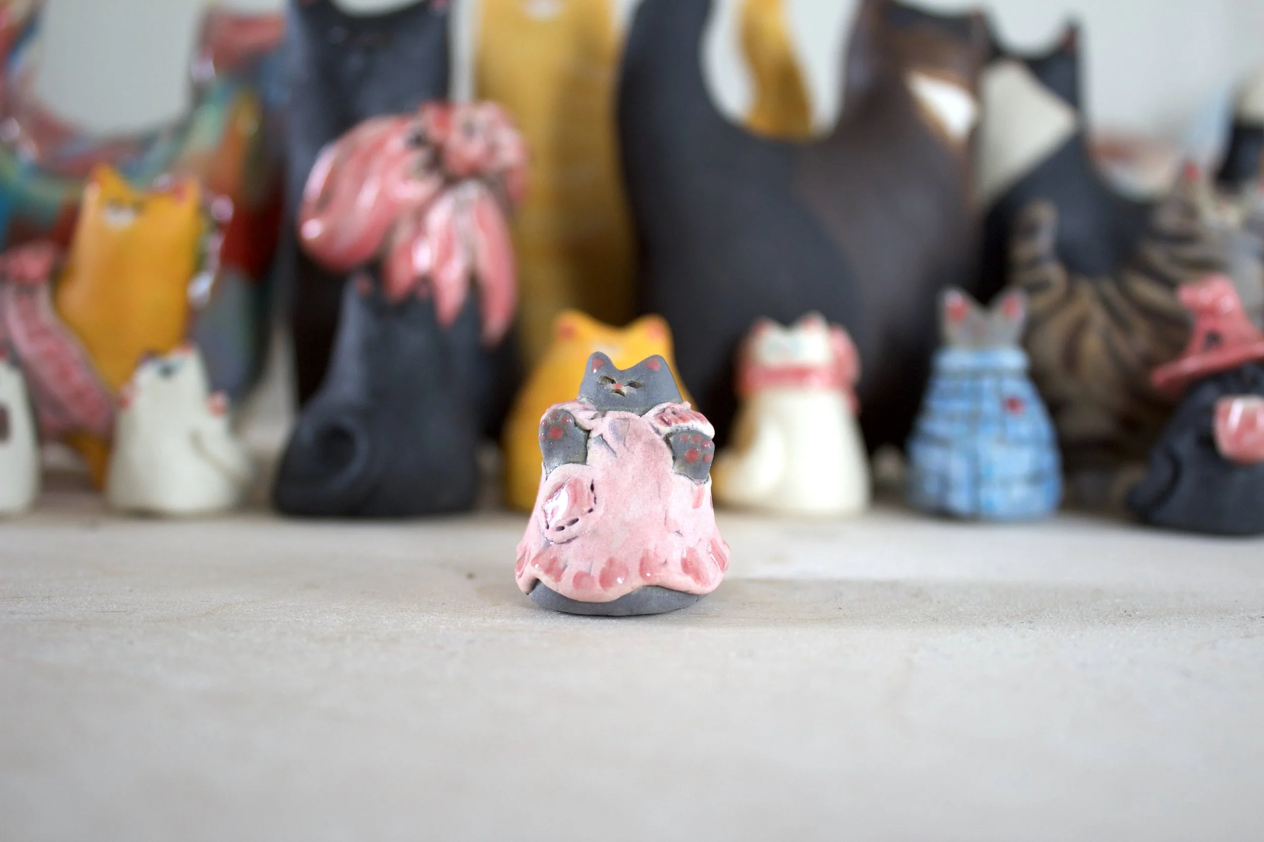 Gray handmade ceramic cat chime with pink apron and pocket.jpeg