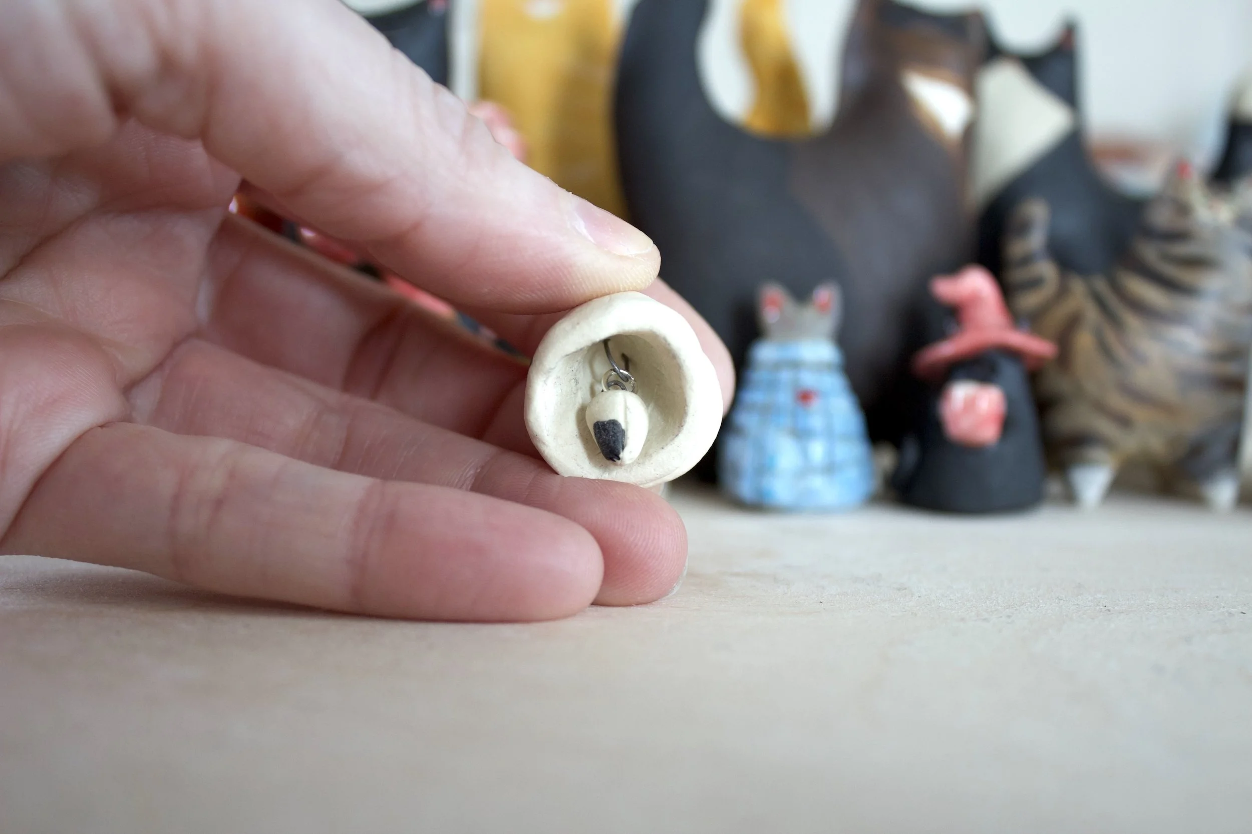 Piebald ceramic cat chime paw clapper.jpeg