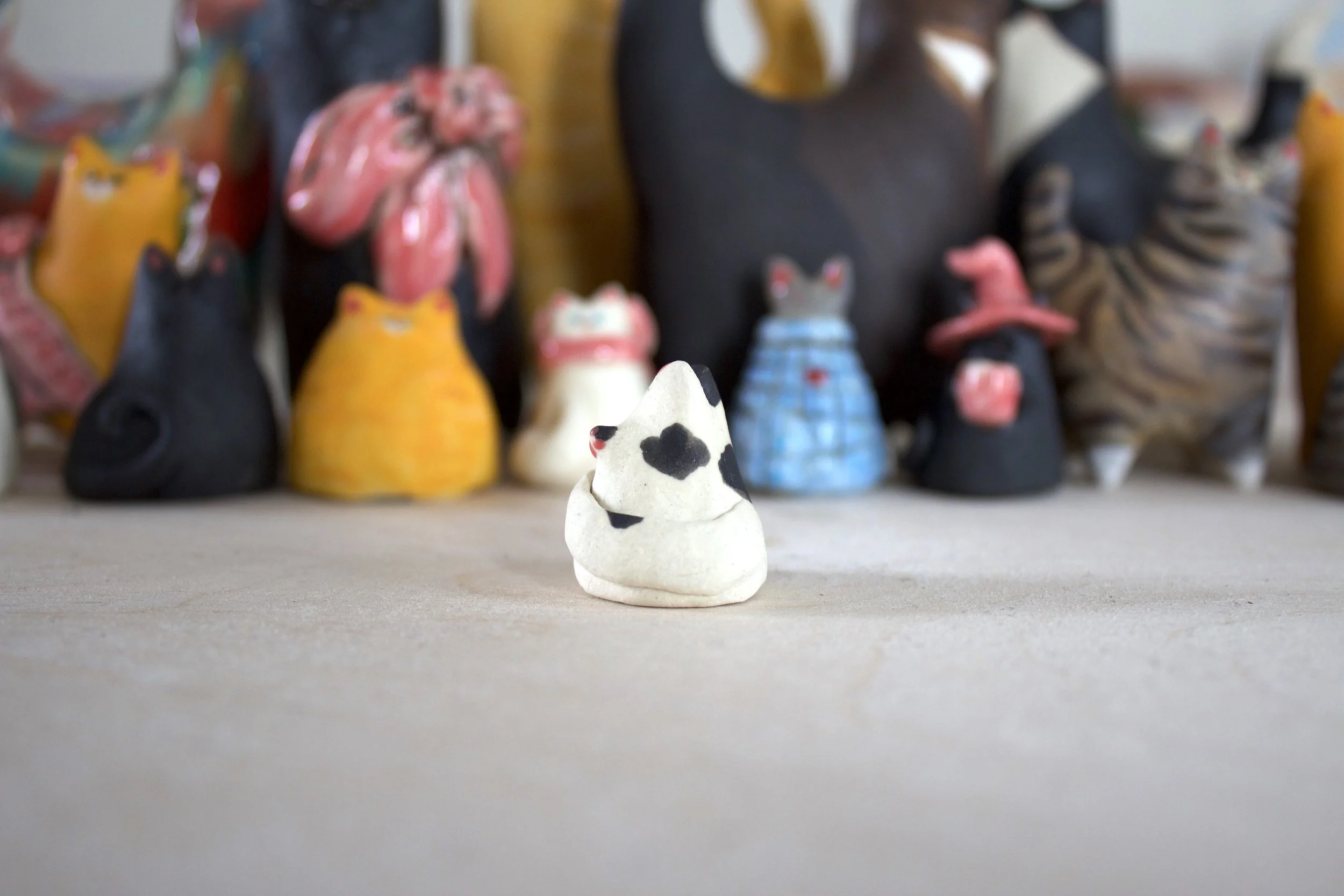 Side view handmade piebald ceramic cat chime sculpture.jpeg
