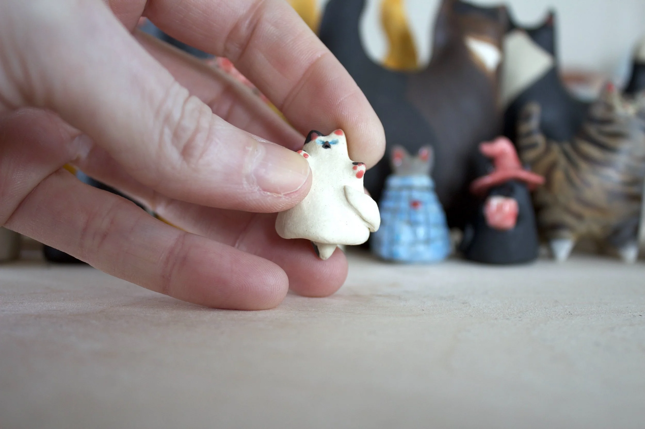 Piebald ceramic cat chime shown in hand for scale.jpeg