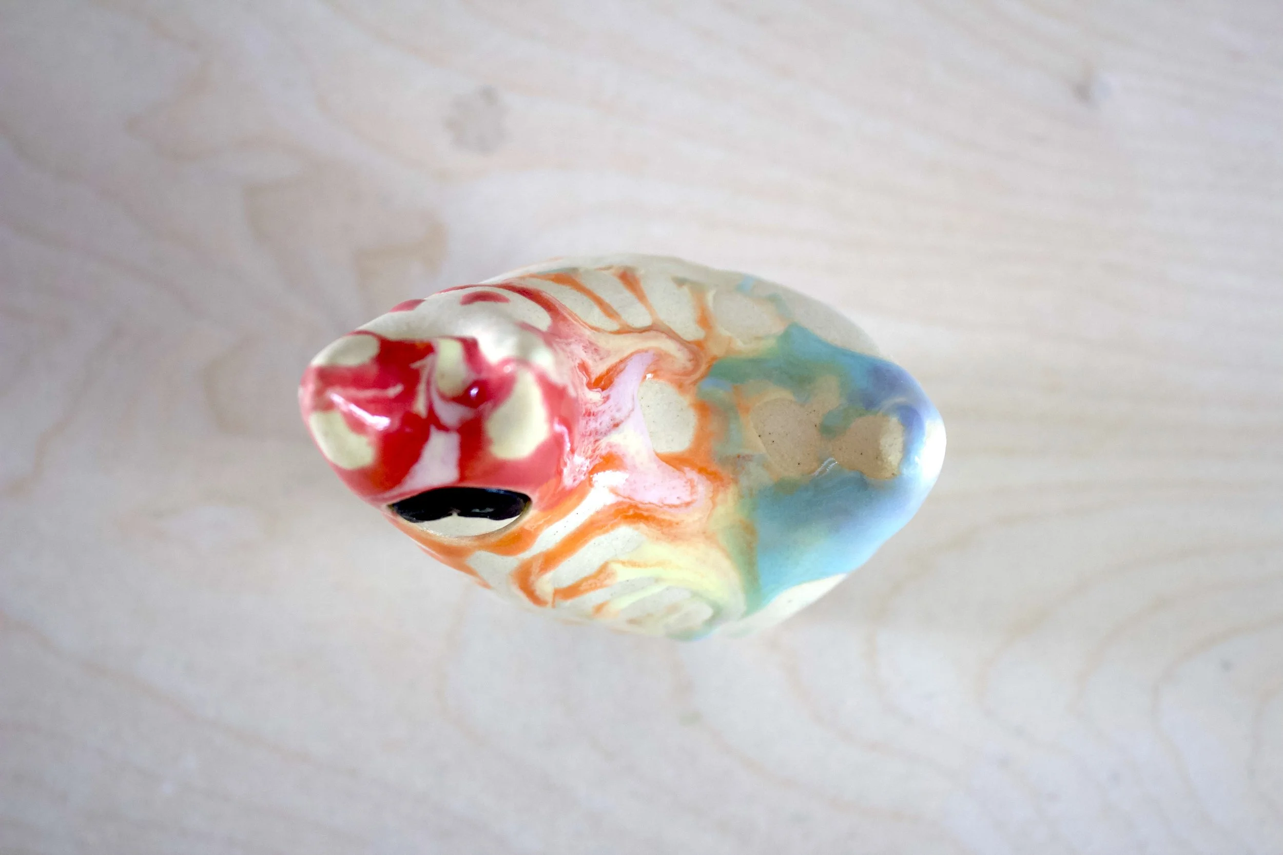 Top view of the handmade large ceramic Pastel Rainbow Goo Skeleton Cat sculpture.jpeg