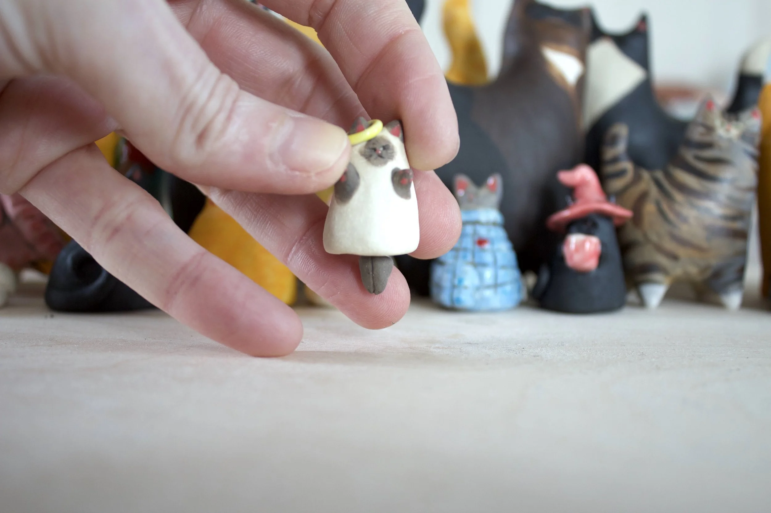 Lilac Point Siamese angel ceramic cat chime shown in hand for scale.jpeg