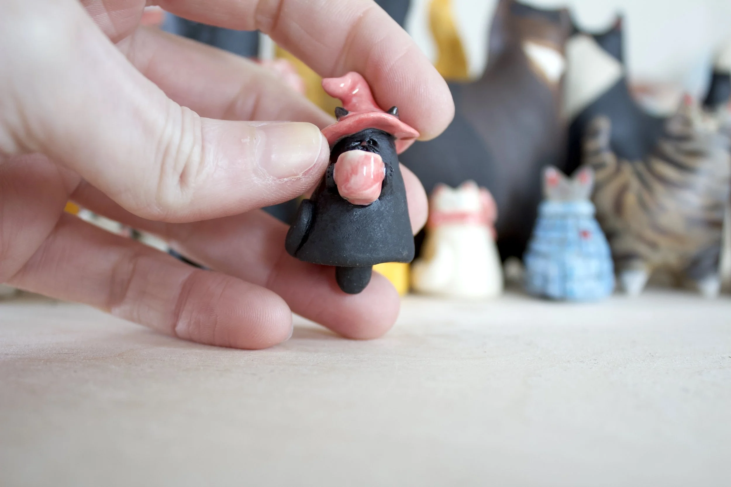 Midnight witch ceramic cat chime shown in hand for scale.jpeg