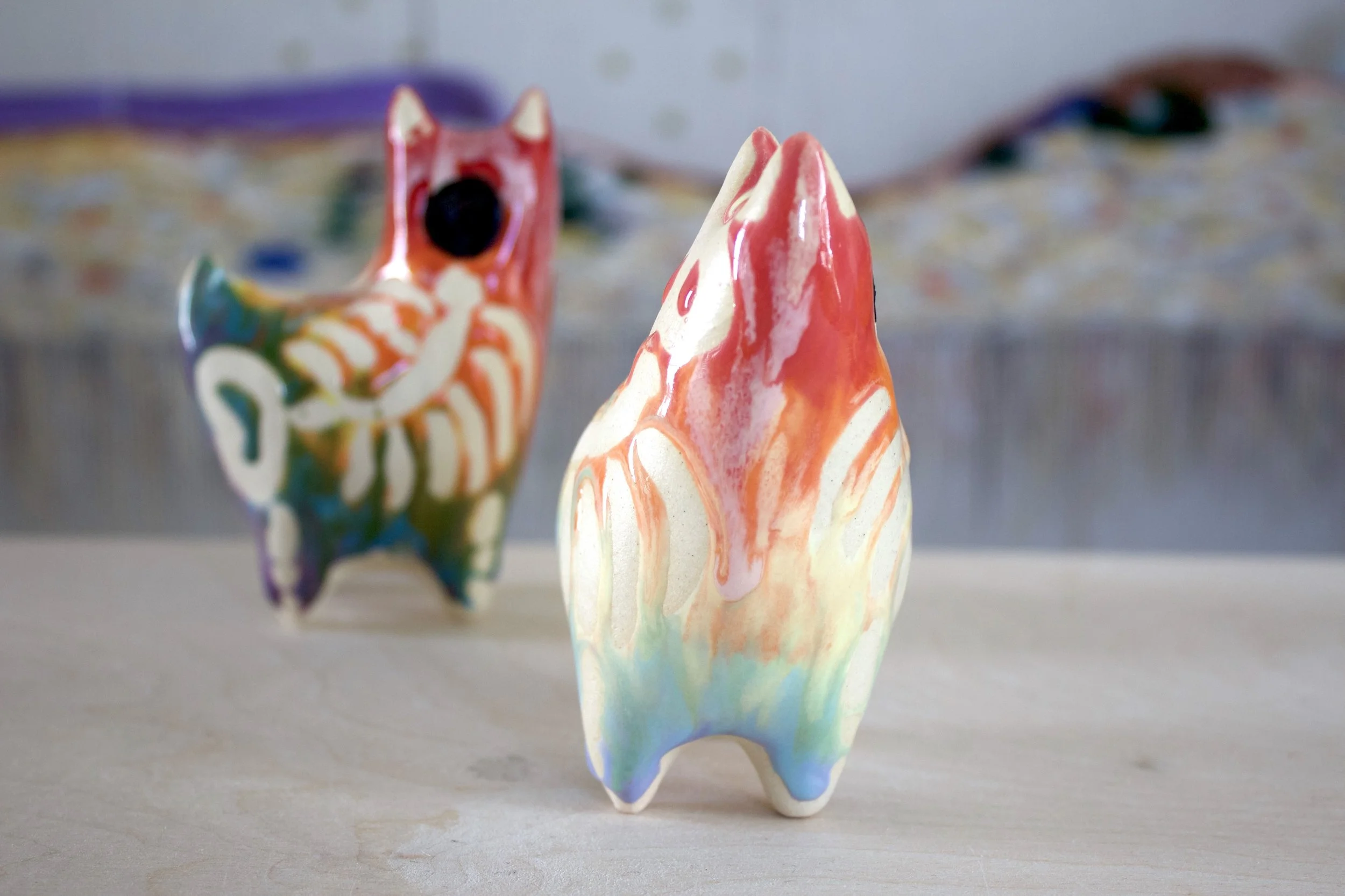 Side view of the handmade large ceramic Pastel Rainbow Goo Skeleton Cat sculpture.jpeg