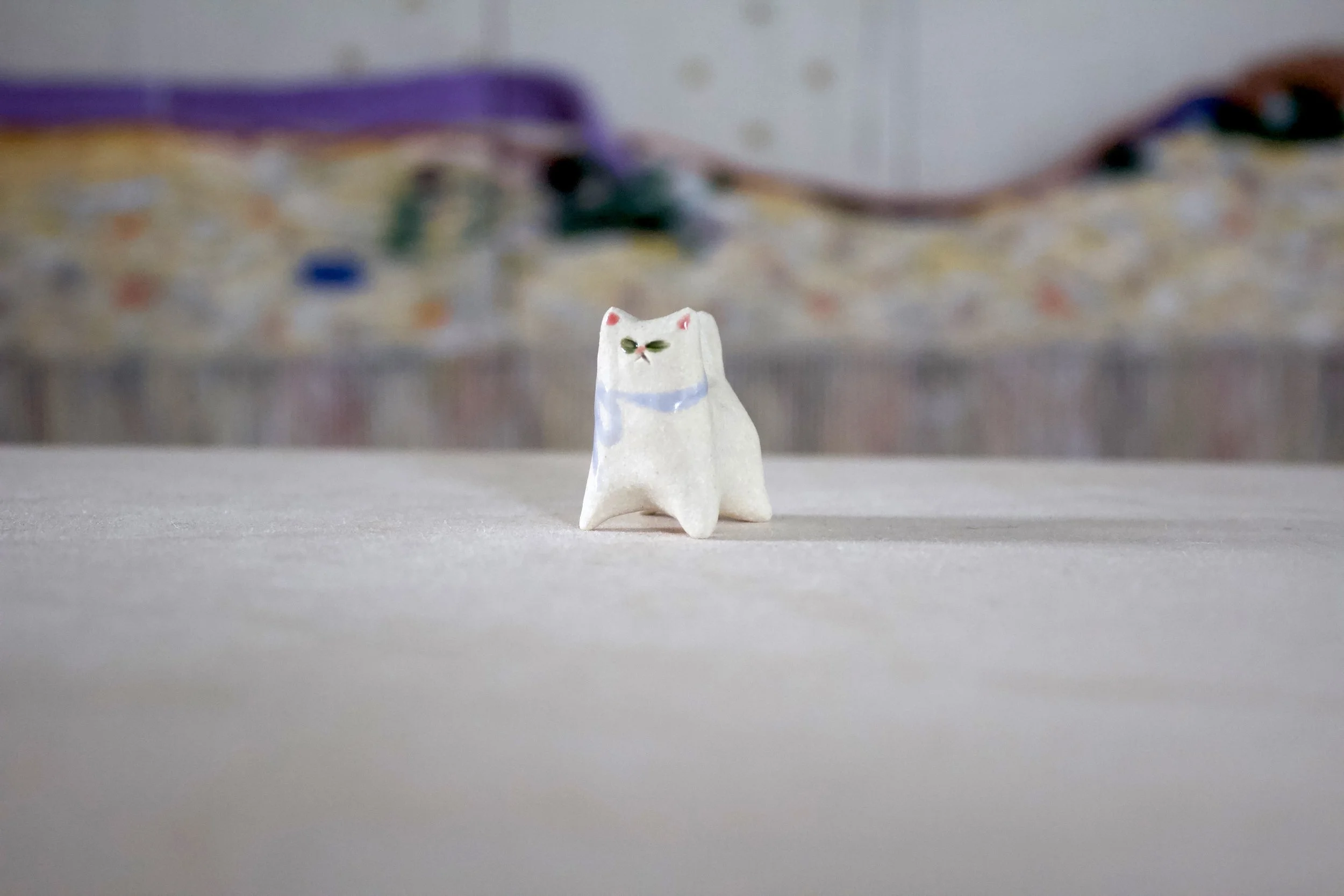 White Cat with Purple Bow and Green Eyes - Classic Cat Sculpture with Food Bowl