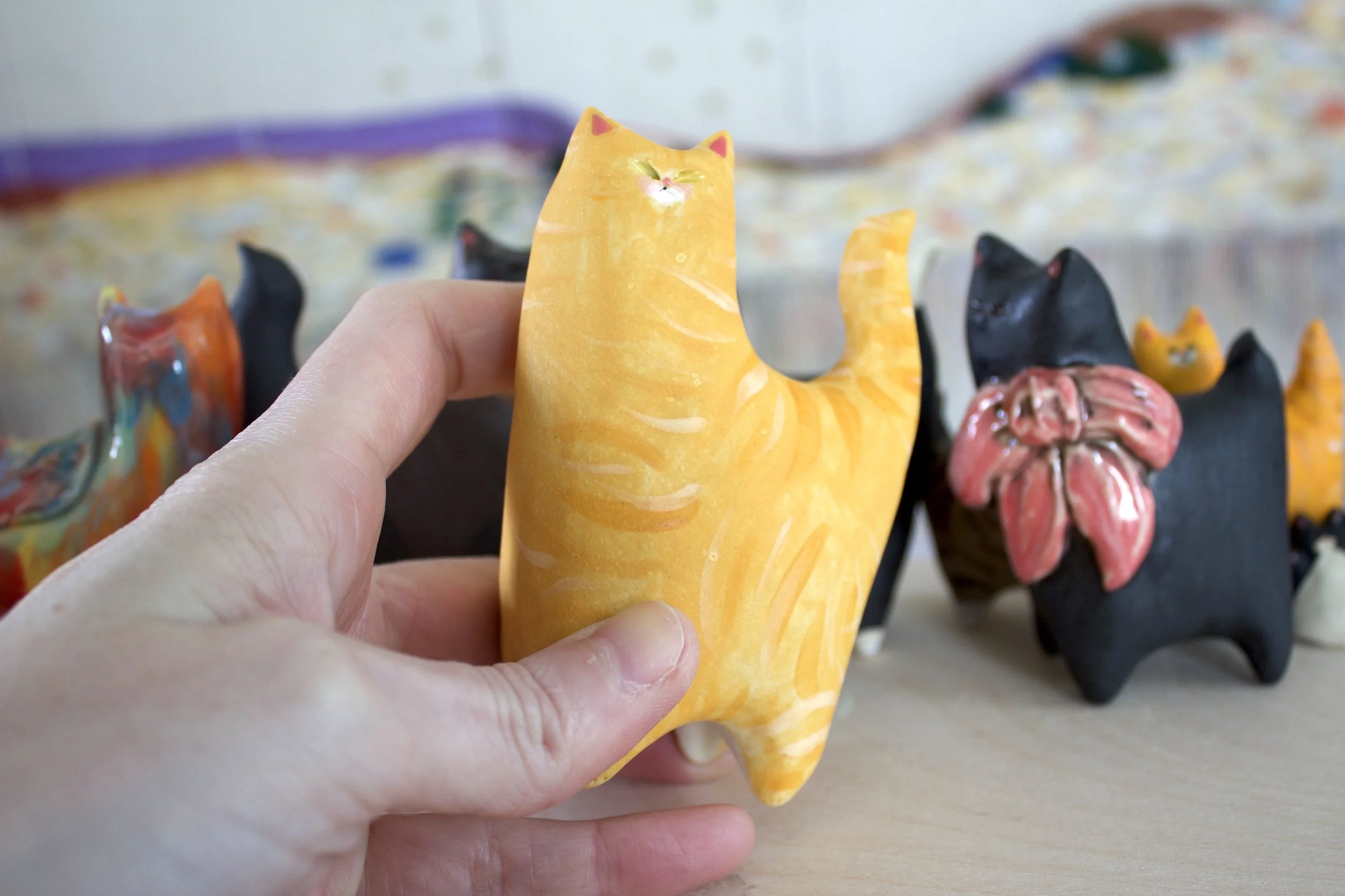 Ginger Tabby ceramic cat sculpture shown in hand for scale.jpeg